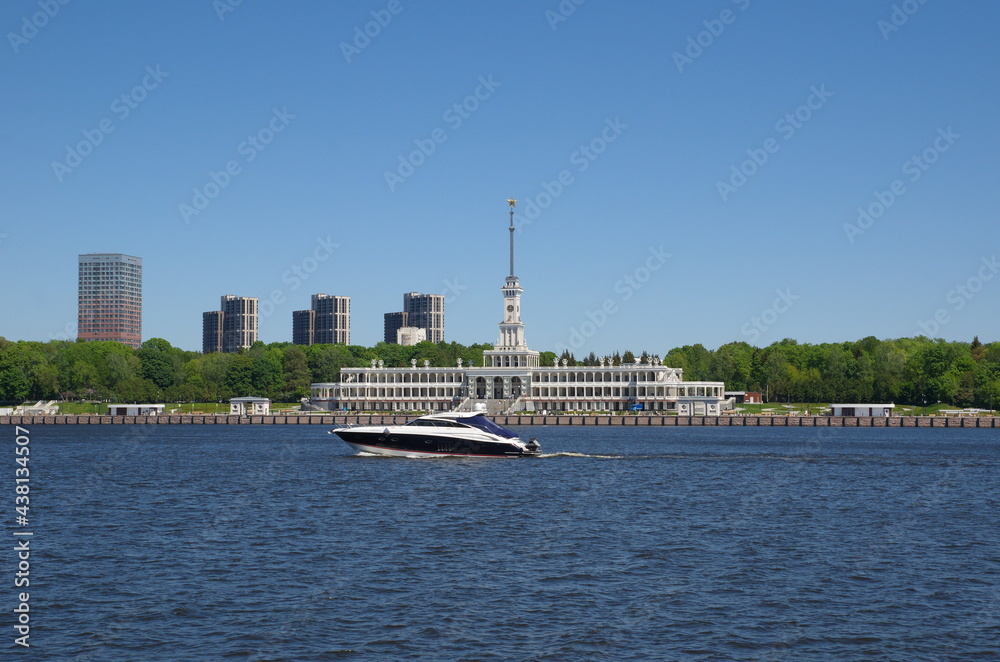Moscow, Russia - June 3, 2021: The building of the Northern River Station and a yacht sailing along the channel named after Moscow