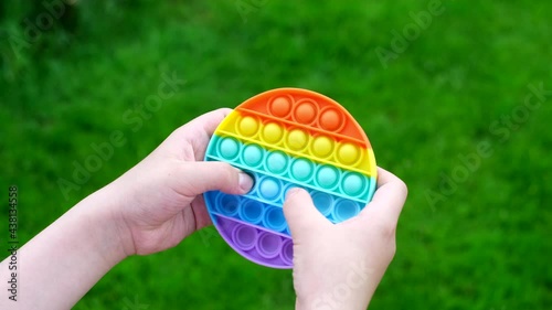 New popular silicone popit toy, baby is playing with it. Rainbow Trendy Pop it fidget toy