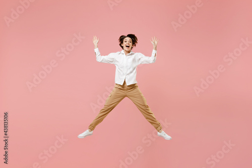 Full length overjoyed young successful employee business woman 20s corporate lawyer in classic formal white shirt work in office jump high with outstretched hands isolated on pastel pink background © ViDi Studio