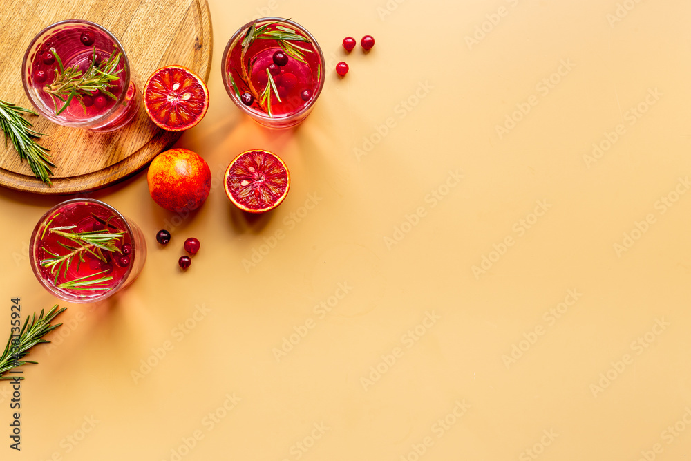 Fototapeta premium Glasses of cranberry lemonade and red oranges with rosemary