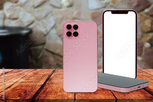Three smartphones on an old wooden table white blank screen