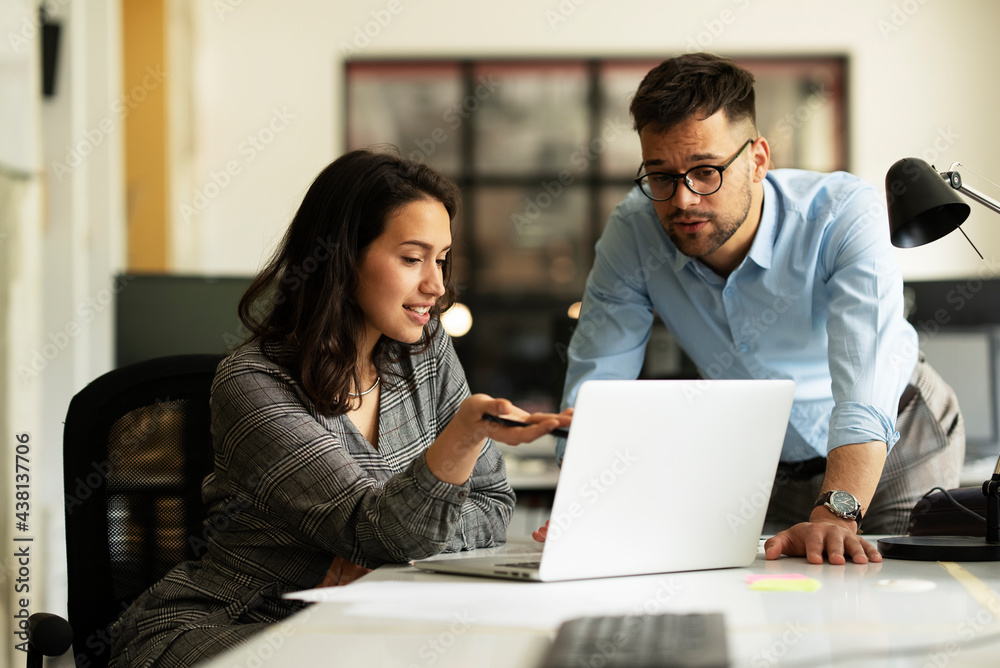Colleagues in office. Businesswoman and businessman discussing work in office. Colleagues in office. Businesswoman and businessman discussing work in office.