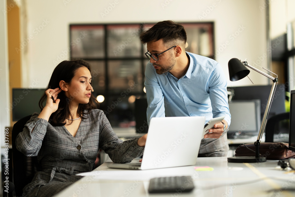 Colleagues in office. Businesswoman and businessman discussing work in office. Colleagues in office. Businesswoman and businessman discussing work in office.