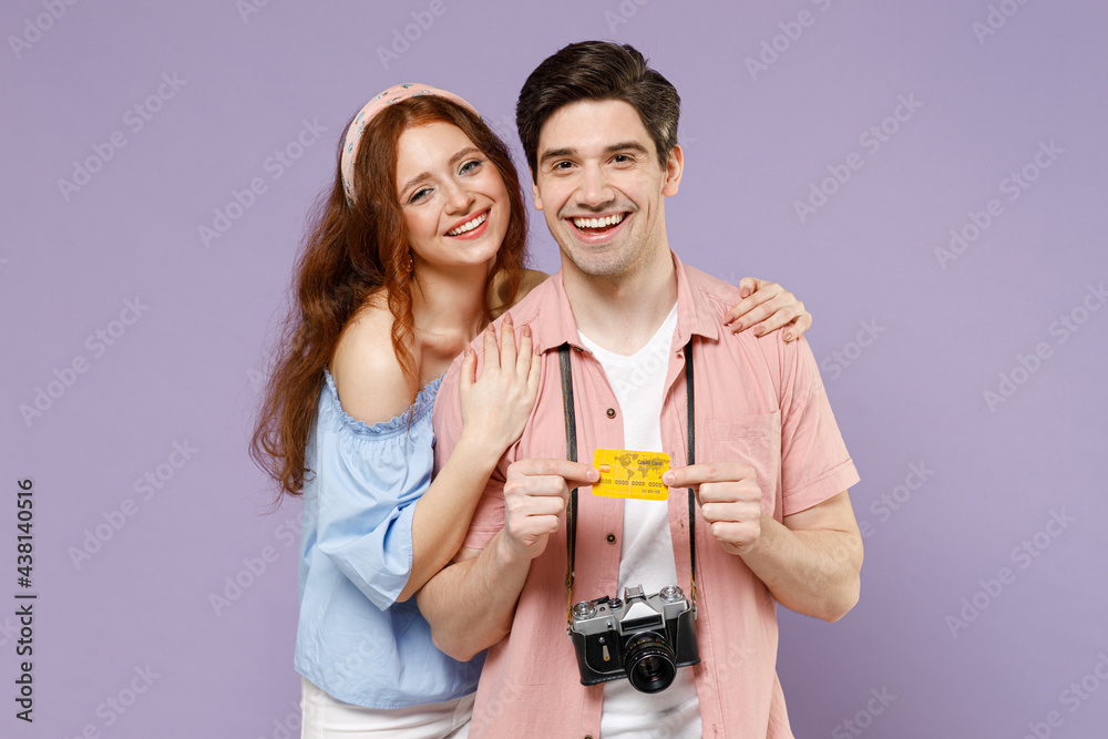 Two smiling happy traveler tourist woman man couple in shirt hold credit bank card look camera hug isolated on purple background Passenger travel abroad on weekends getaway Air flight journey concept. Two smiling happy traveler tourist woman man couple in shirt hold credit bank card look camera hug isolated on purple background Passenger travel abroad on weekends getaway Air flight journey concept.