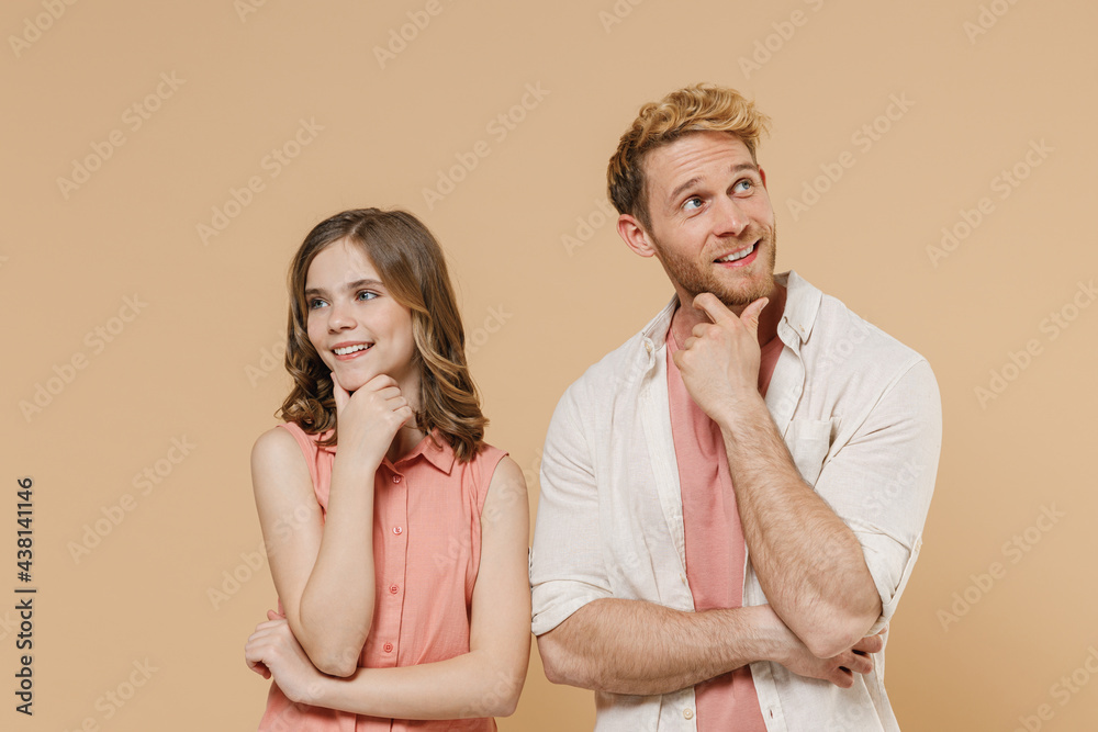 Young wistful parent man have fun with cute child teen girl in casual pastel clothes. Daddy little kid daughter look aside prop up chin isolated on beige background Father's Day Love family concept. Young wistful parent man have fun with cute child teen girl in casual pastel clothes. Daddy little kid daughter look aside prop up chin isolated on beige background Father's Day Love family concept.