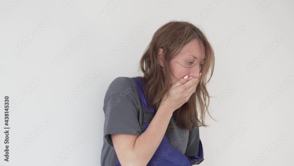 A tired woman in the form of a worker yawns, a close-up. A tired woman in the form of a worker yawns, a close-up.