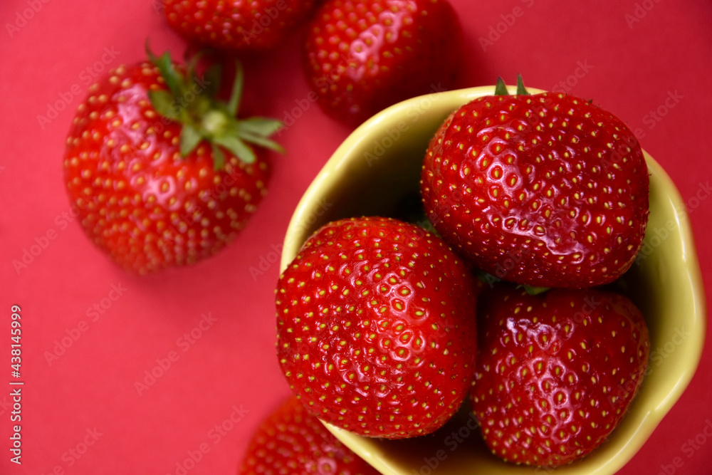 Strawberries in a bowl top view close-up stock images. Pile of fresh ripe strawberries on a red background stock photo Strawberries in a bowl top view close-up stock images. Pile of fresh ripe strawberries on a red background stock photo