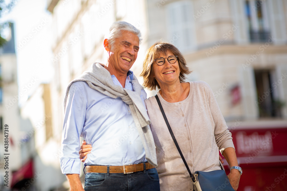 smiling older couple standing outside in city