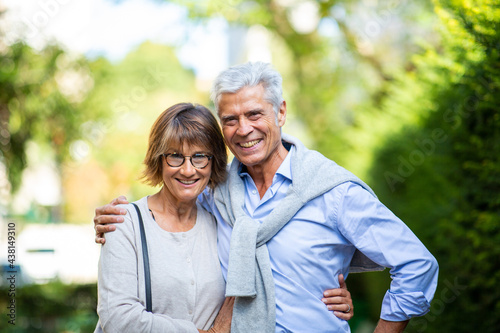 smiling older couple standing outside in park