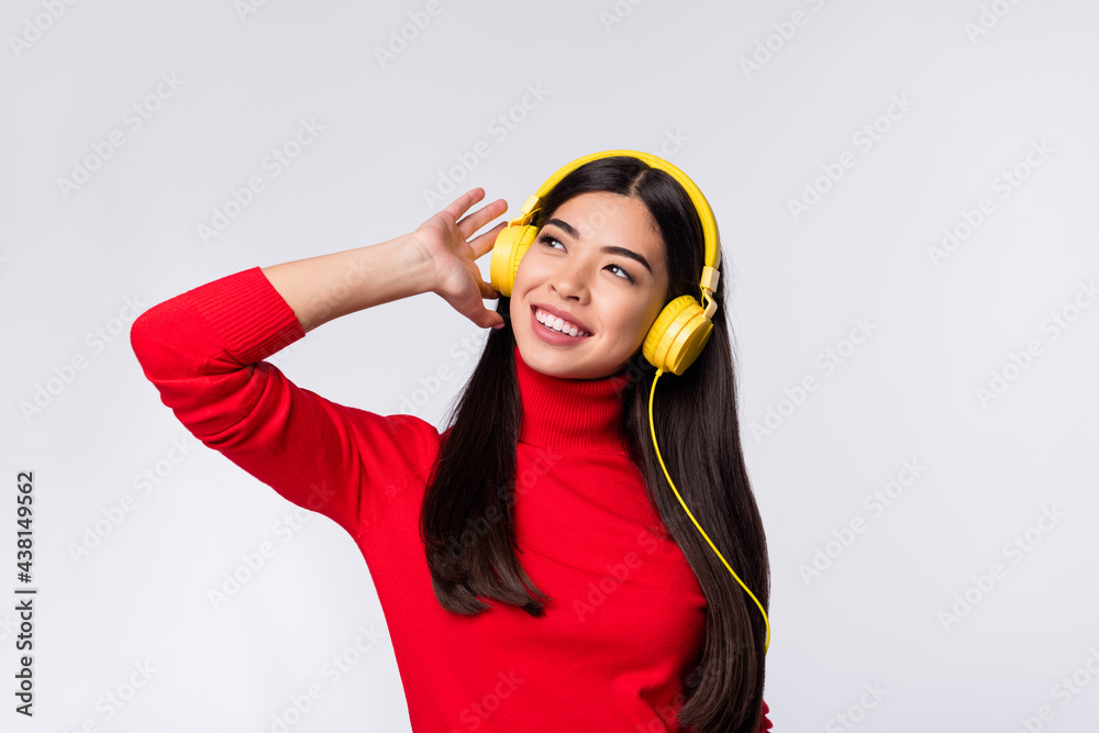 Photo of happy beautiful good mood pretty asian girl listen music headphones look copyspace isolated on grey color background Photo of happy beautiful good mood pretty asian girl listen music headphones look copyspace isolated on grey color background