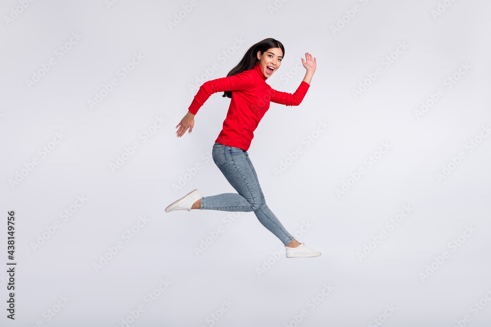 Full size profile side photo of happy excited good mood asian girl running fast in air isolated on grey color background