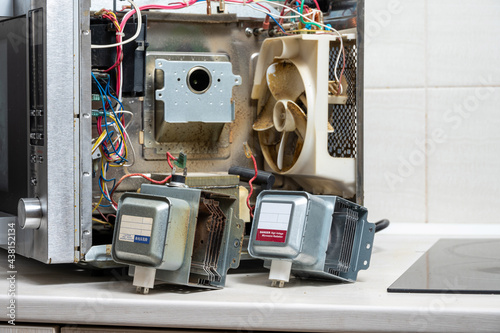 New and old magnetrons next to the disassembled microwave photo