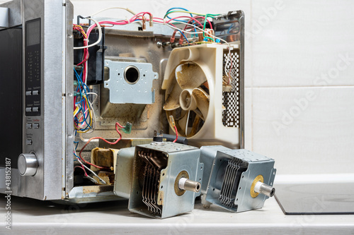 New and old magnetrons next to the disassembled microwave photo