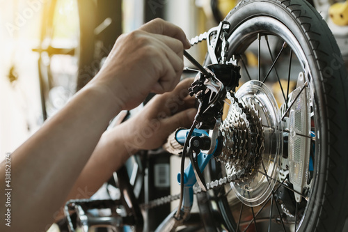 Tableau sur toile Bike mechanic repairs folding bicycle in Workshop