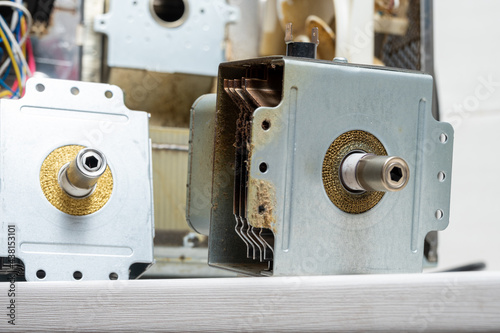 New and old magnetrons next to the disassembled microwave photo