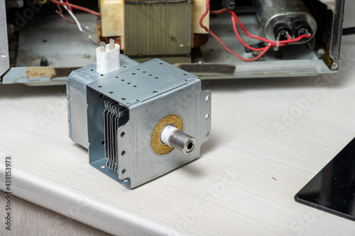 New magnetron next to the disassembled microwave photo