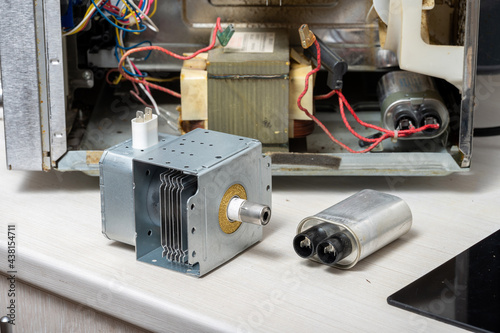 New magnetron and capacitor next to the disassembled microwave photo
