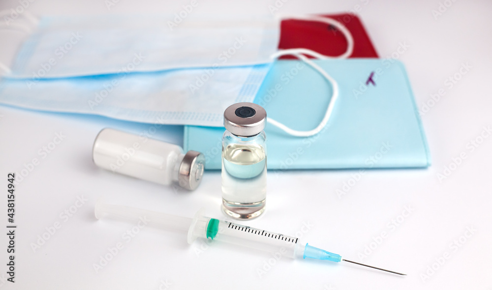Vaccine, syringe, passports and medical masks on a white background. Travel concept. Close-up. Vaccine, syringe, passports and medical masks on a white background. Travel concept. Close-up.