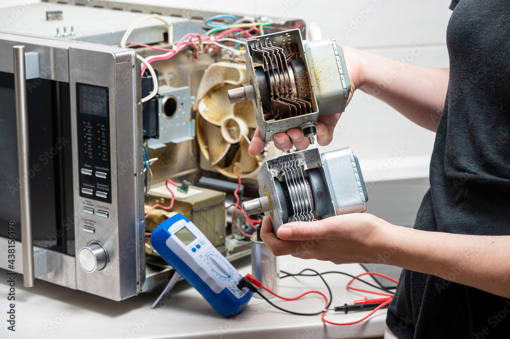 Repair of the microwave oven. The woman shows the old and new