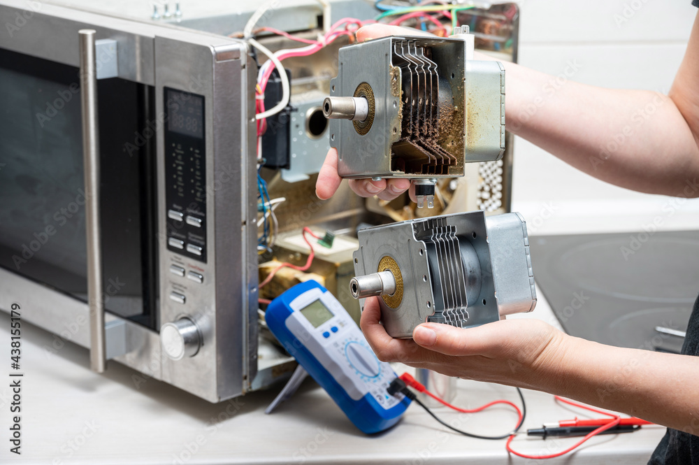 Repair of the microwave oven. The woman shows the old and new