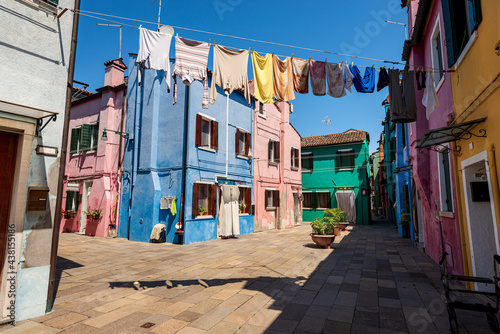 Old small multi colored houses (bright colors) in Burano island in a sunny spring day. Venice lagoon, UNESCO world heritage site, Veneto, Italy, southern Europe.