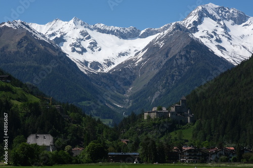 Campo Tures, Bolzano, Italy - June 1, 2021: Burg Taufers castle in Val Pusteria. With a snow-covered mountain in background. Italian alps. Sunny spring day.