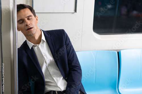 male businessman sleeping inside the subway train