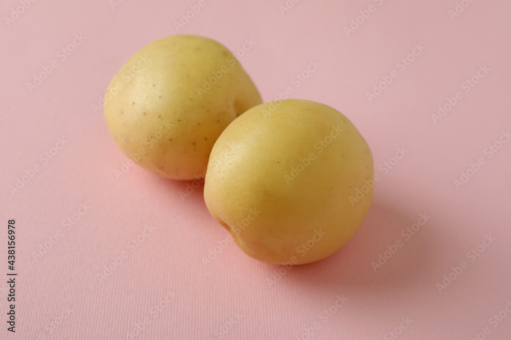 Young potato on pink background, close up Young potato on pink background, close up
