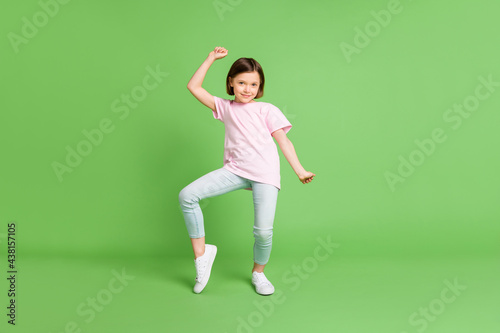 Full size photo of young lovely girl happy positive smile have fun dance isolated over green color background