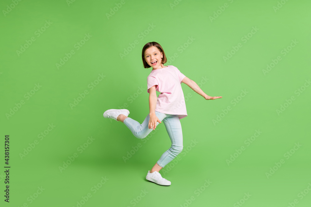 Full body profile side photo of young excited girl happy positive smile enjoy music dance isolated over green color background Full body profile side photo of young excited girl happy positive smile enjoy music dance isolated over green color background