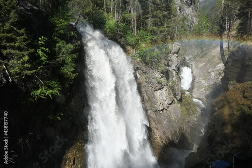 The fabulous alpine waterfalls of Riva in the Dolomites (Campo Tures) with rainbow. Path of San Francesco. Lovely place in the Alps. Sunny spring day with no people. Trentino Alto Adige. photo