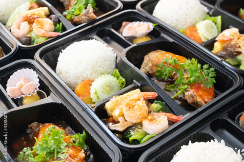 Thai food lunch boxes in plastic packages.