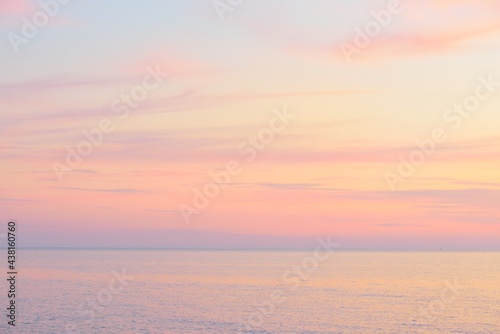 Fototapeta Naklejka Na Ścianę i Meble -  Baltic sea at sunset. Dramatic sky, blue and pink glowing clouds, soft golden sunlight, midnight sun. Picturesque dreamlike seascape, cloudscape, nature. Panoramic view