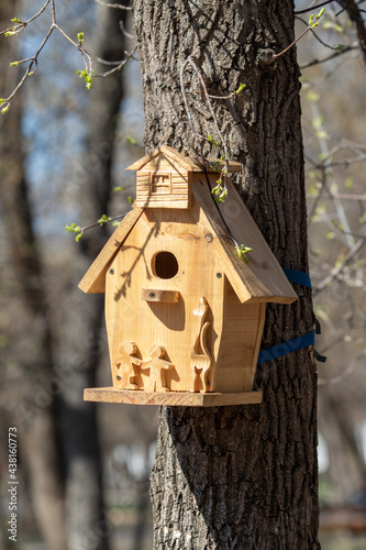 wooden birdhouse hanging on the tree spring park