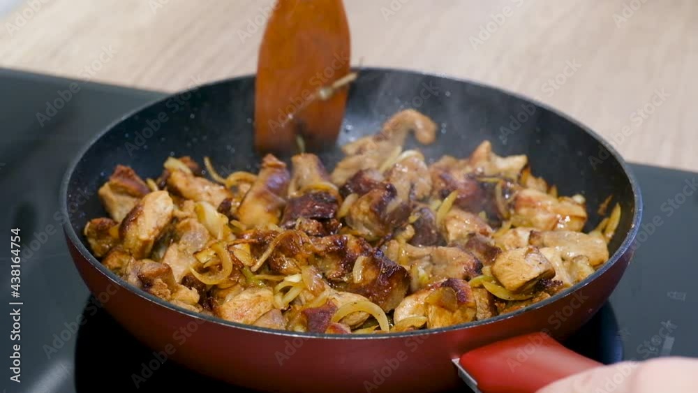 4K Mixing Fried Meat Stew with Onion in pan on stove. Close up