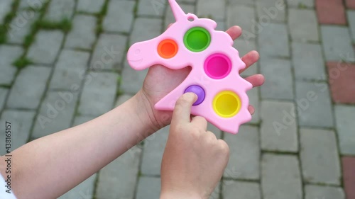 New popular silicone popit toy, baby is playing with it. Rainbow Trendy Pop it fidget toy