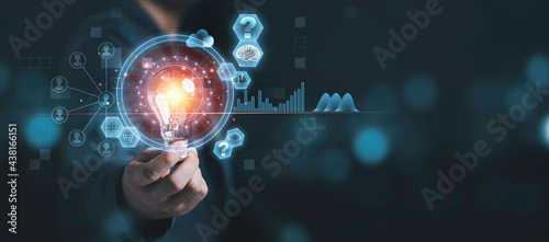 Businessman holding lightbulb with virtual brain and infographic, reative thinking ideas and innovation concept. photo