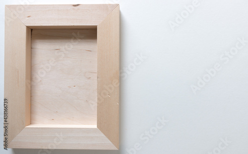 rear, verso, or back side of a wooden easel panel, showing wooden supports (with corners cut at 45 degrees) isolated on white-grey photographed from above in a flay lay style