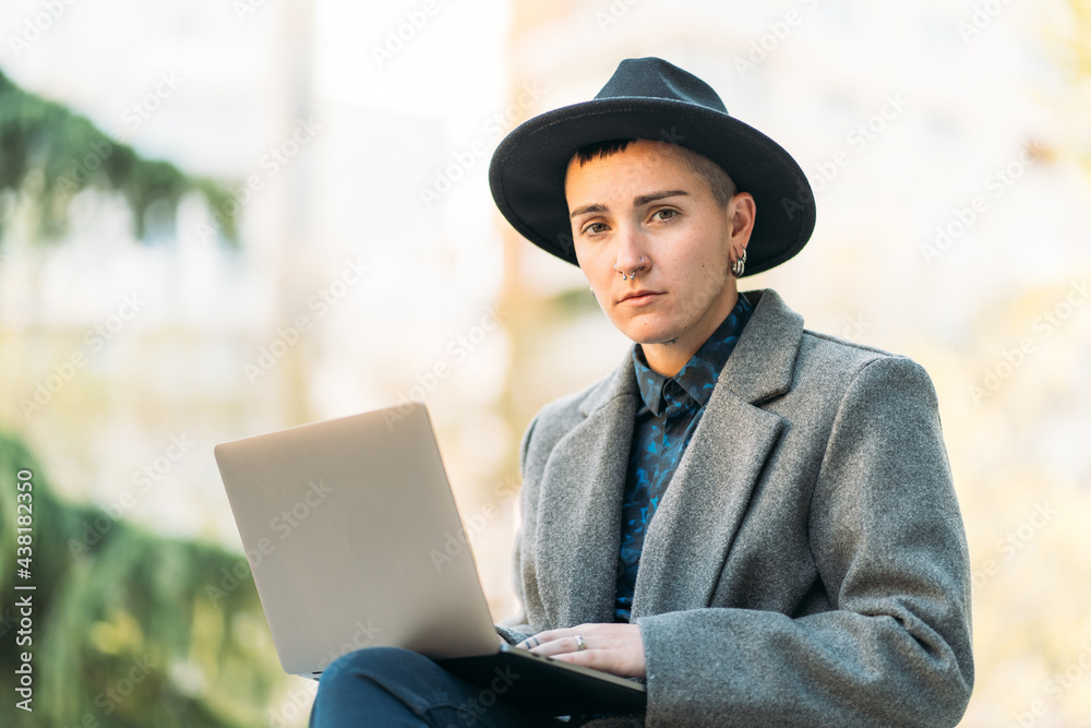 Transsexual person typing on laptop in town Transsexual person typing on laptop in town