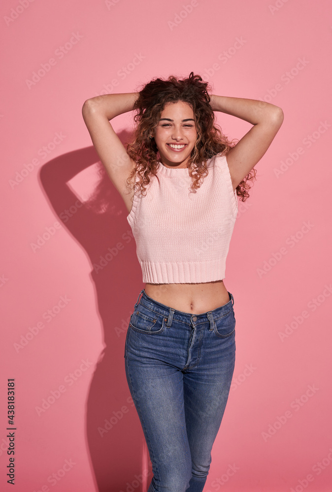 Happy woman with hands behind head in studio