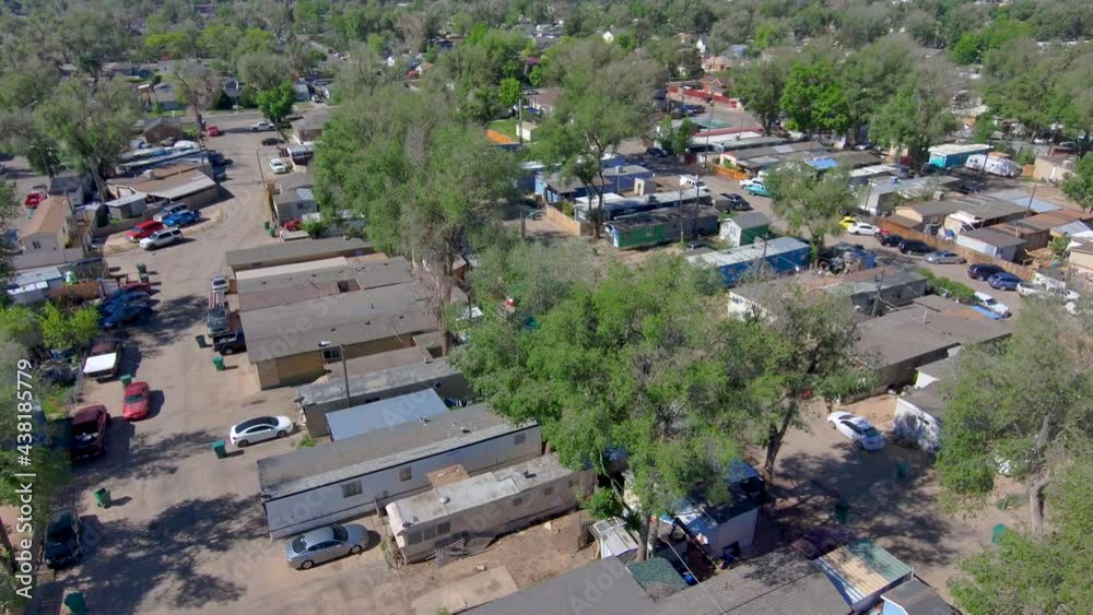 A high dolly shot of a poor low income neighborhood.  Mobile homes in 2021.