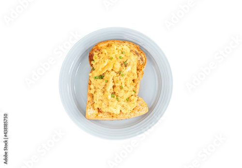Scrambled eggs served with toasted bread on a blue plate. isolated white background. clipping path.