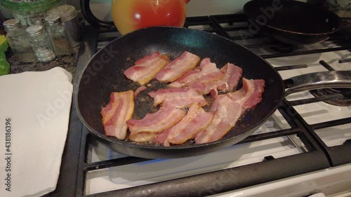 thick cut bacon sizzling in a hot skillet on a gas stove in grandma's kitchen photo