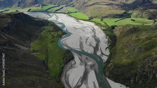 Aerial of Matukituki River, tilt up to high mountain scenery, New Zealand photo