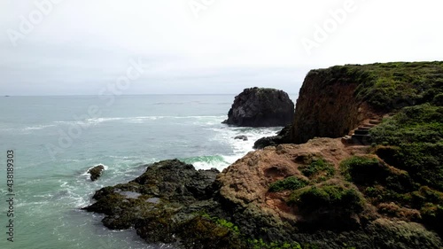 Aerial video of oceanside cliffs along the California coast mountains. 