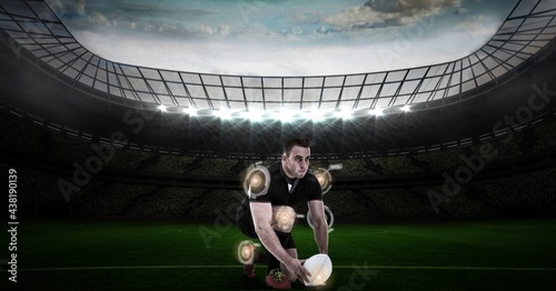 Multiple round scanners over caucasian male rugby player placing a rugby ball against stadium