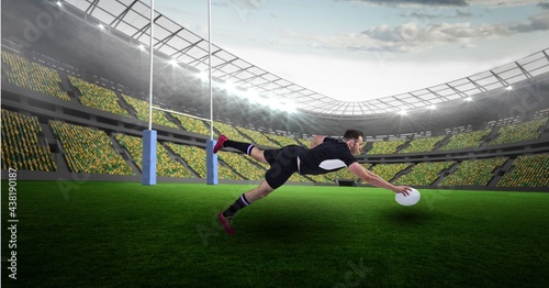 Caucasian male rugby player holding a rugby ball diving against stadium