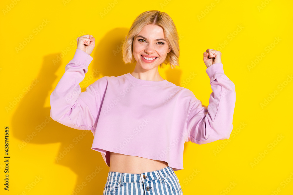 Portrait of attractive cheerful blond girl rejoicing great luck having fun isolated over bright yellow color background Portrait of attractive cheerful blond girl rejoicing great luck having fun isolated over bright yellow color background