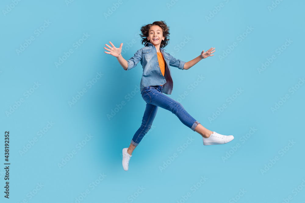 Full size profile side photo of young preteen boy happy positive smile go walk jump isolated over blue color background