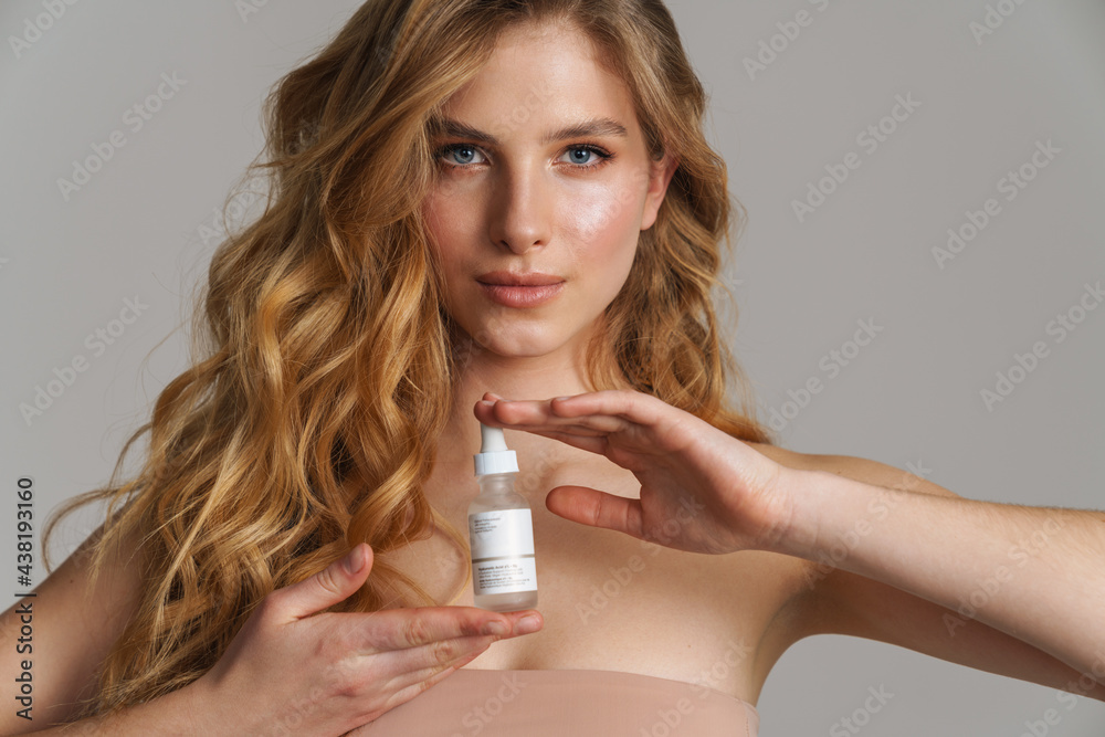 Half-naked white ginger woman posing with face serum Half-naked white ginger woman posing with face serum